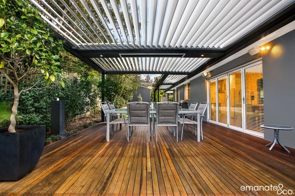 Outdoor table setting on timber deck under louvered patio cover