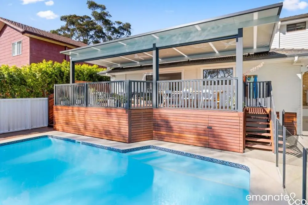 Raised alfresco deck with fencing close to boundary, overlooking backyard swimming pool.