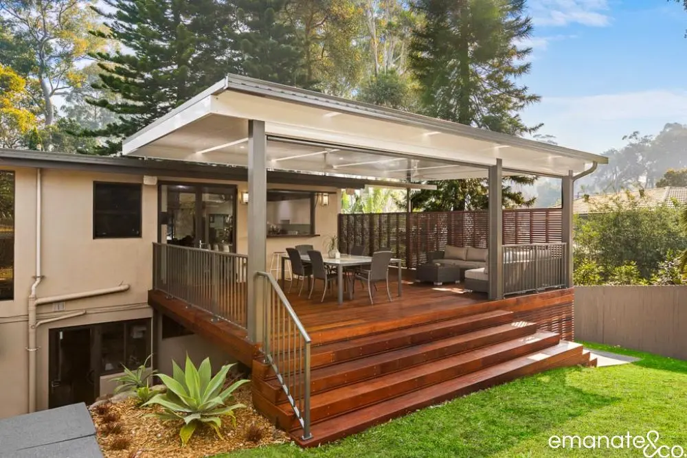 Modern alfresco deck in Normanhurst with rich timber flooring, integrated ceiling cover, and seamless indoor-outdoor lifestyle transition.
