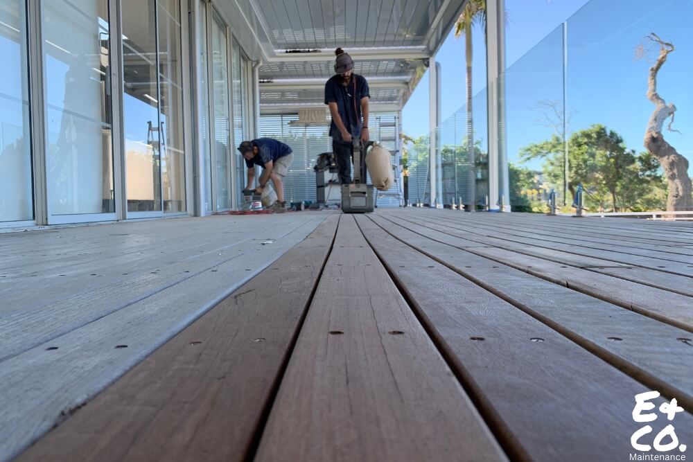 E&Co team sanding a timber deck in Sydney to restore natural wood appearance and prolong durability.