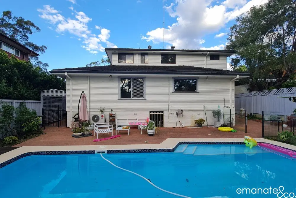 Elevated timber alfresco deck with privacy screens built near boundary, overlooking pool.