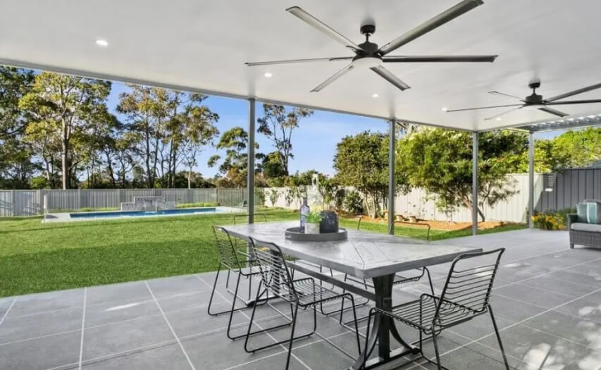 Non-combustible outdoor room extension by Emanate and Co engineered for Bushfire Flame Zone (BAL-FZ) compliance, featuring premium stone tiles, steel posts, and an insulated flyover roof.