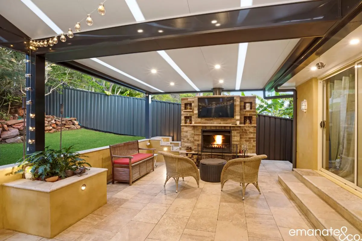 Premium covered outdoor living area with built-in fireplace, television and tiled patio in Turramurra, ideal for all-season entertaining.