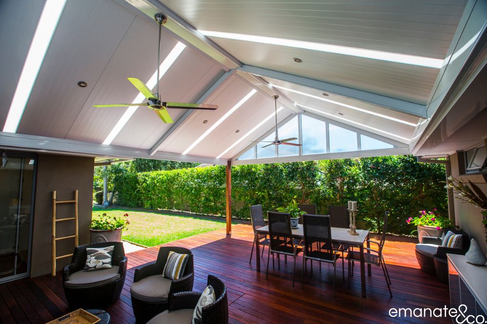 Architectural gabled insulated patio roof with skylight strips, ceiling fans and glazed end panels above a hardwood alfresco entertaining deck.