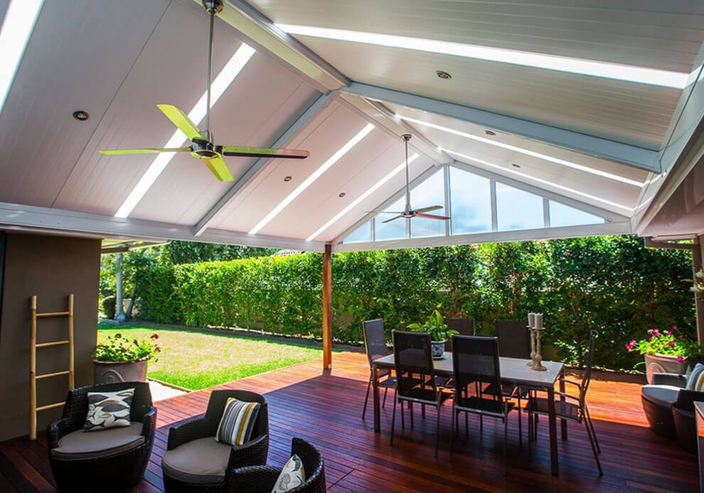 High gabled insulated patio roof cover over timber deck with ceiling fans and alfresco dining in Avalon by Emanate and Co.