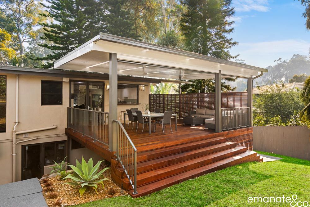 Completed Normanhurst outdoor room with hardwood decking, insulated patio cover, dining and lounge zones, privacy screening and broad garden steps.