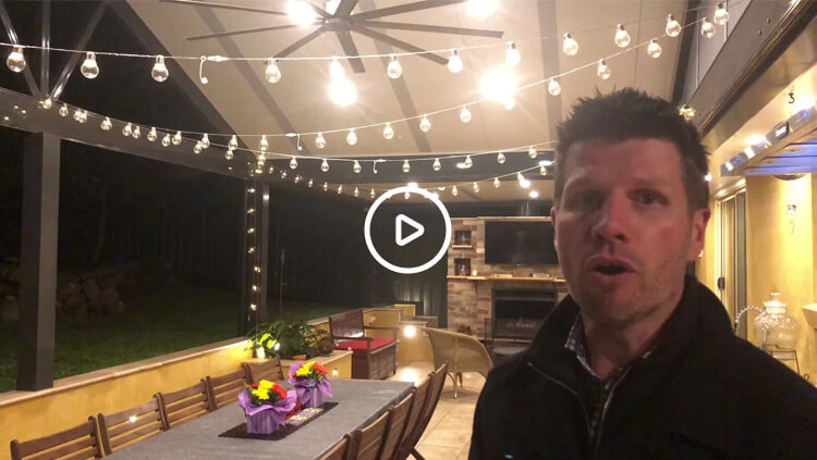 Video thumbnail of an on-site outdoor room review in Berowra by Emanate and Co featuring festoon lighting, outdoor fireplace, and dining space at night.
