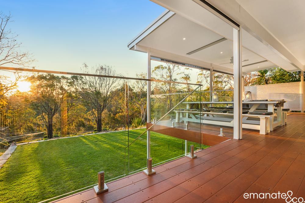 West Pymble outdoor living room with covered timber deck, glass balustrade and bushland outlook, designed for relaxed year-round entertaining.
