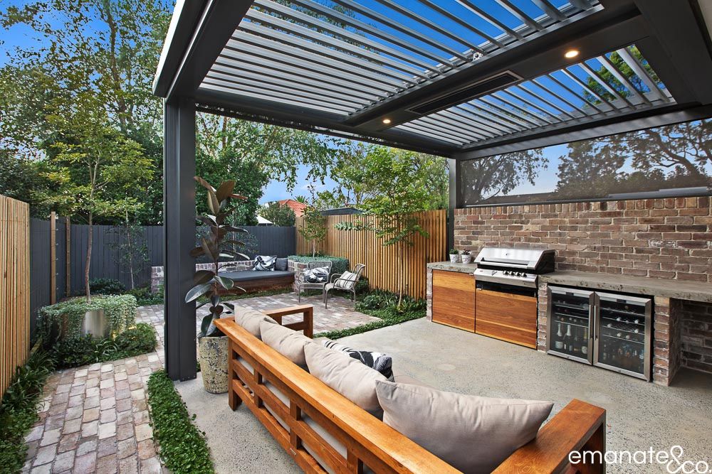 Cammeray outdoor room with opening louvre roof, integrated outdoor kitchen and lounge seating, creating a private year-round entertaining space.