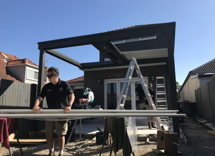 Builders installing an Eclipse opening louvered roof patio structure in Cammeray by Emanate and Co.